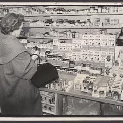 A woman shops for vitamins at a drugstore counter