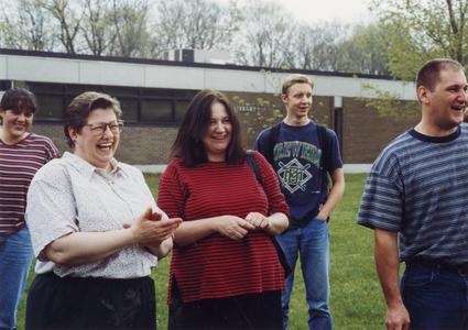 Psychology professor Margaret Hamilton laughs with students in courtyard