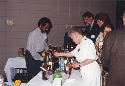 Economics professor Larry Gomes serving drinks at a staff event