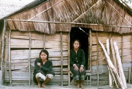 Two Khmu' women are seated in front of their house in Houa Khong Province