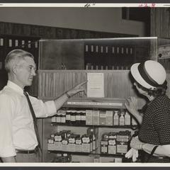 A pharmacist points a customer to air raid instructions