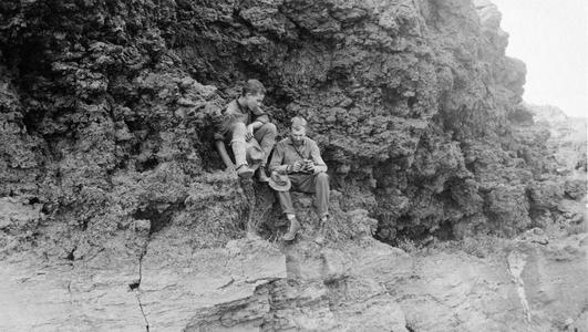 Two men sitting on a cliff