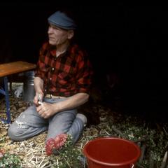 Duncan Williamson inside a bow tent, making wooden flowers