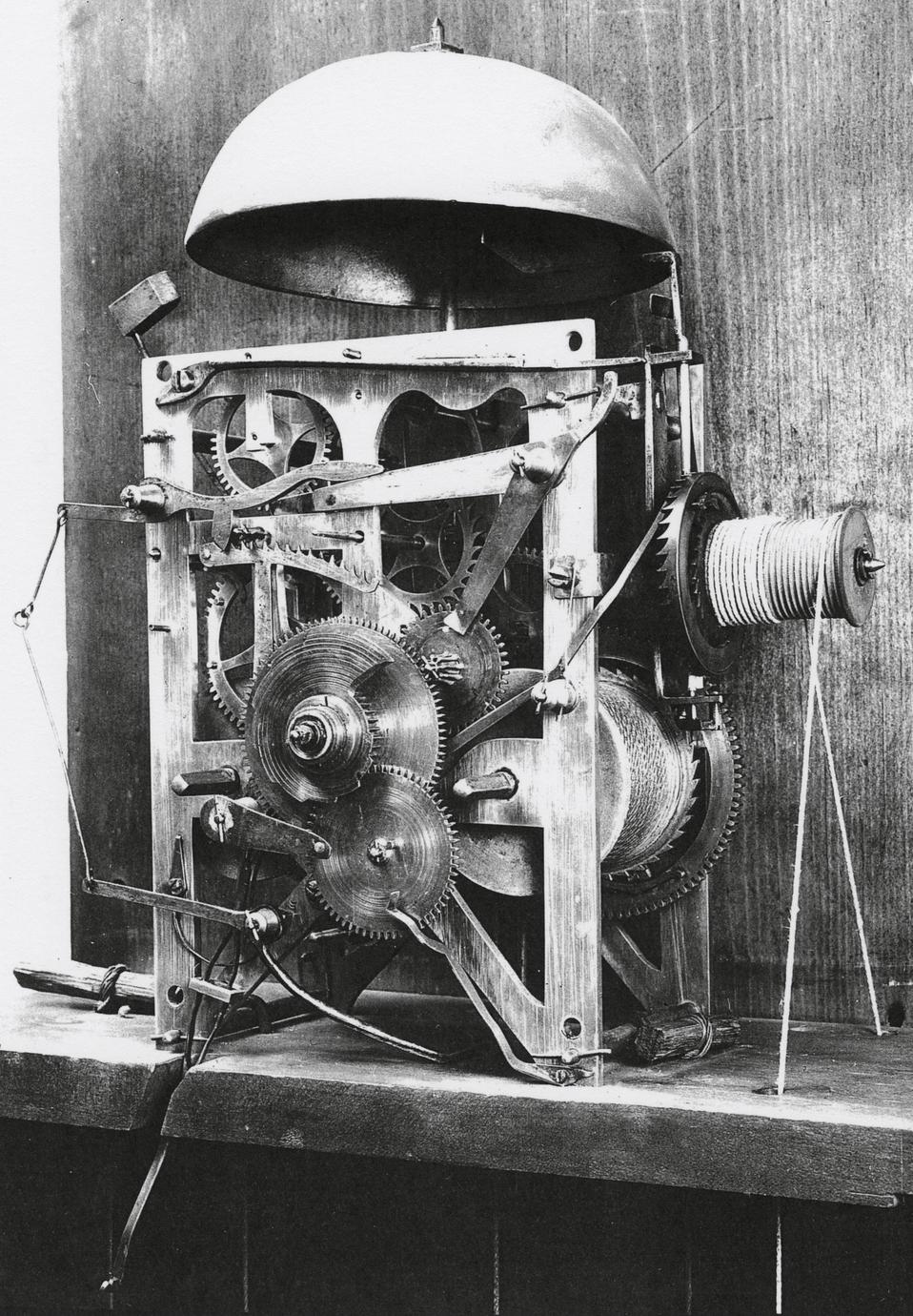 Black and white photograph of the gear system from an eight-day, strike, repeater, alarm clock.