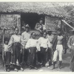 Two American soldiers visit with a group of Filipinos, early 1900s