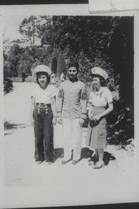 A cadet and two girls in cadet caps, Baguio