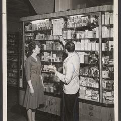 A pharmacist explains pricing of merchandise to a customer