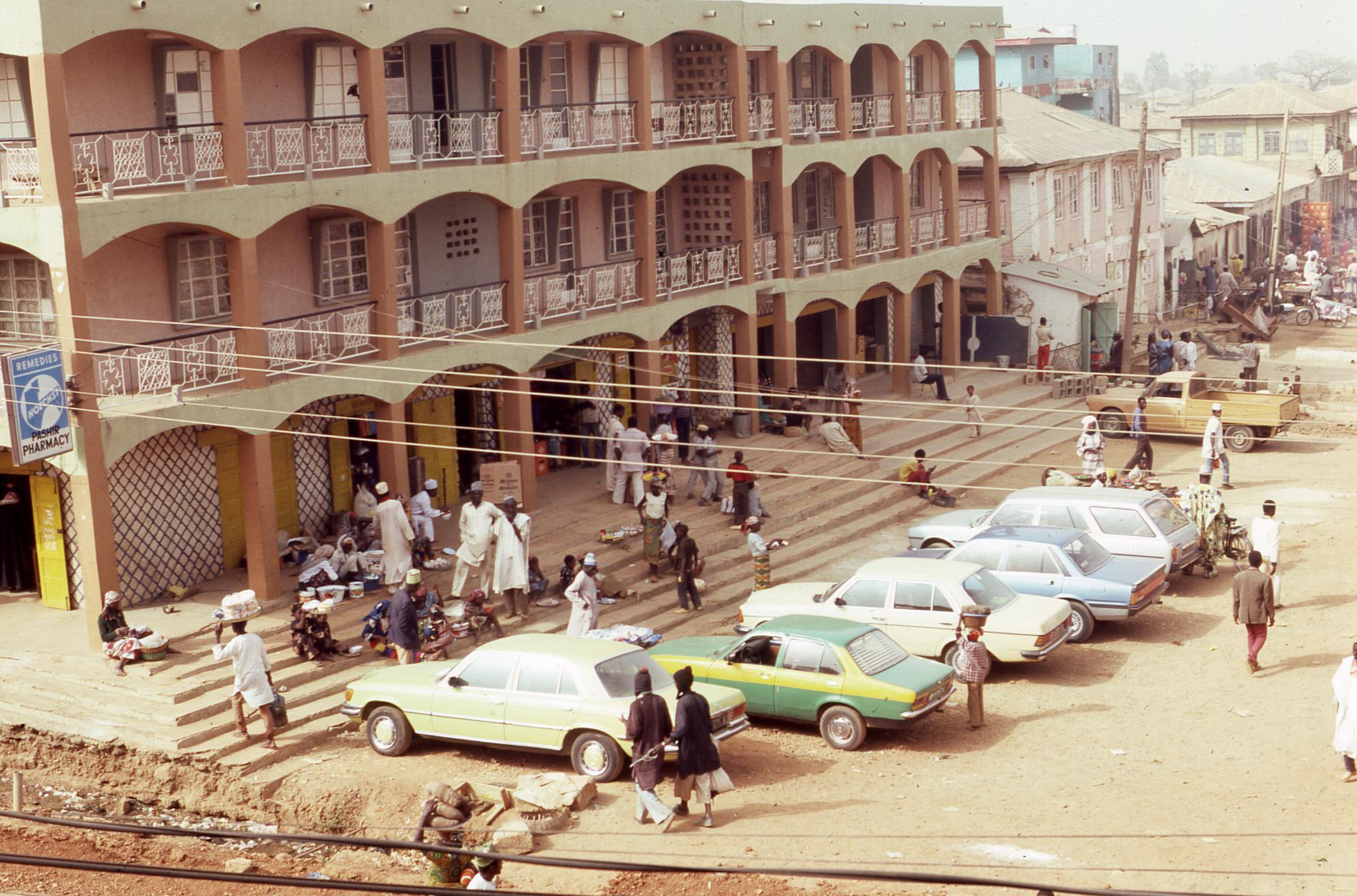 Cars parked outside the Jos market