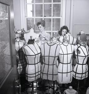 Surrounded by dress mannequins