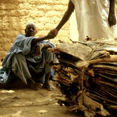 Merchant in Tanout Greeting the Prospective Buyer of a Bundle of Goatskins