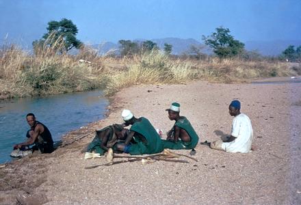 Fulbe Men Resting and Getting Haircut by River
