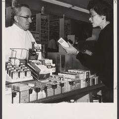 A pharmacist helps a customer select suntan lotion