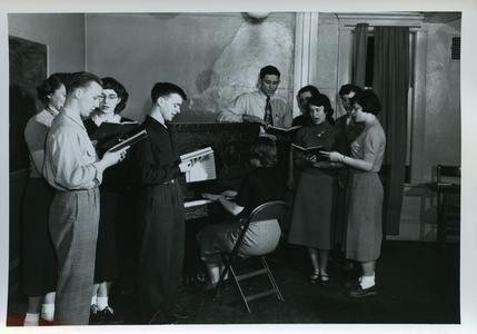 Stout Christian Fellowship members at a meeting, singing and playing the piano