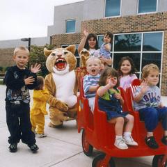 Corby the Cougar with children of the daycare