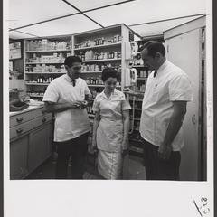 Pharmacy staff pose behind the prescription counter of a drugstore