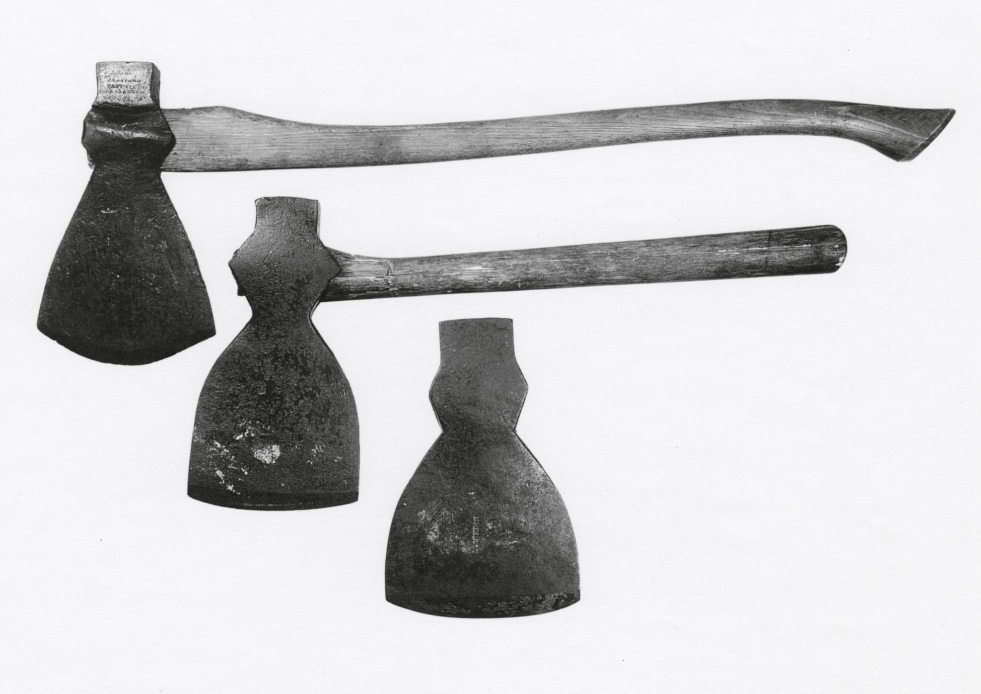Black and white image of two axes with handles and one axe blade alone