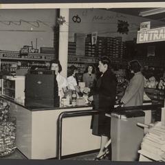 Two women stand at a drugstore checkout counter
