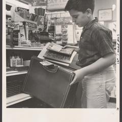 A young shopper tries out a satchel for school supplies