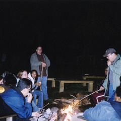 Students sit around a fire