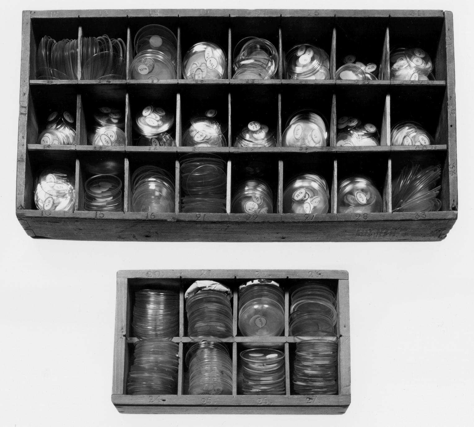 Black and white photograph of watch-glass boxes.