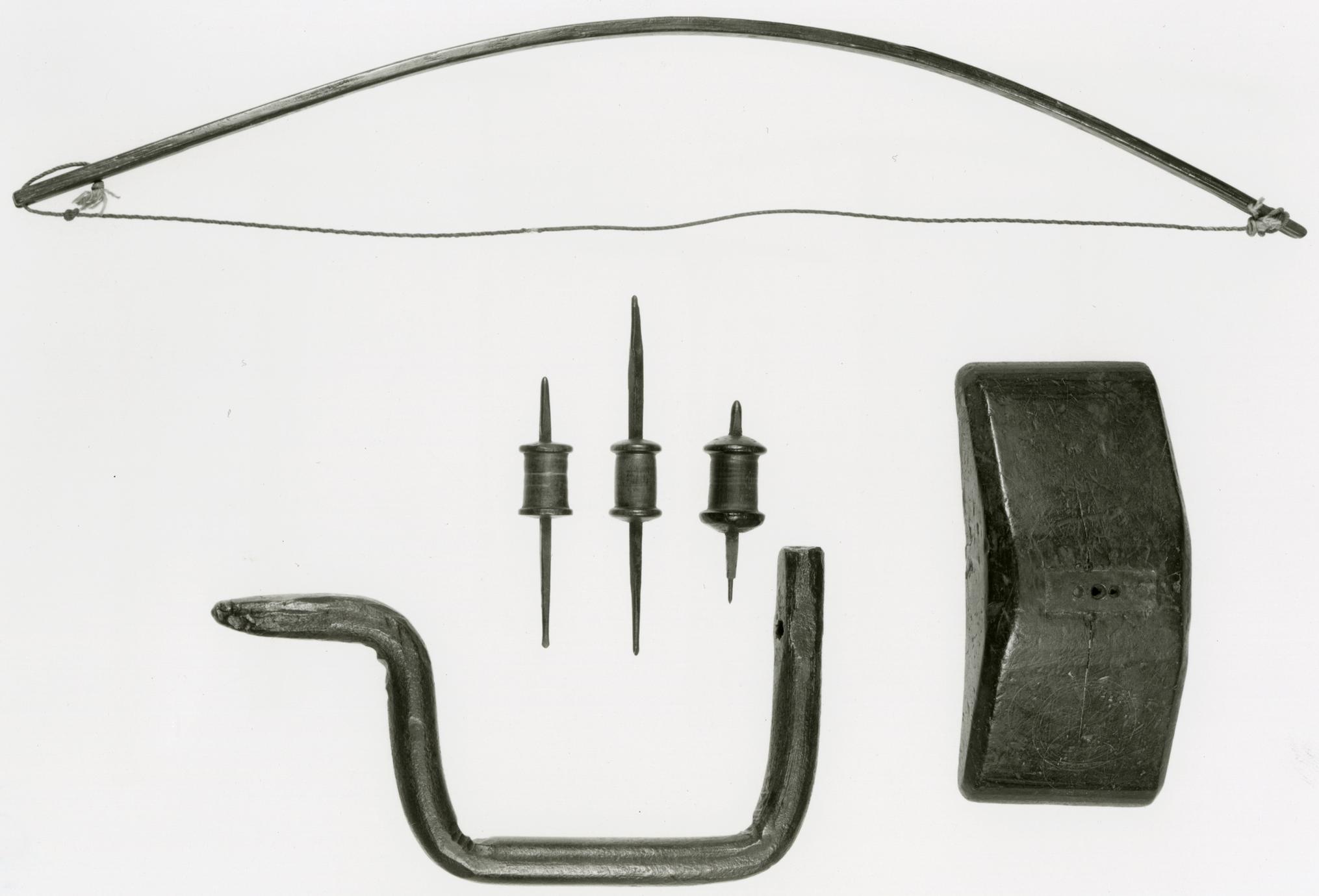 Black and white photo of a bow, barrel drills, smith's brace and breastplate.