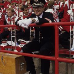 Michael Leckrone seated in stadium with UW band members