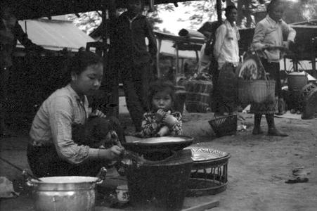 Lao woman with child preparing food for sale