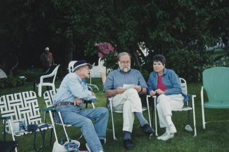 Three people sitting on a lawn