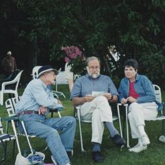 Three people sitting on a lawn